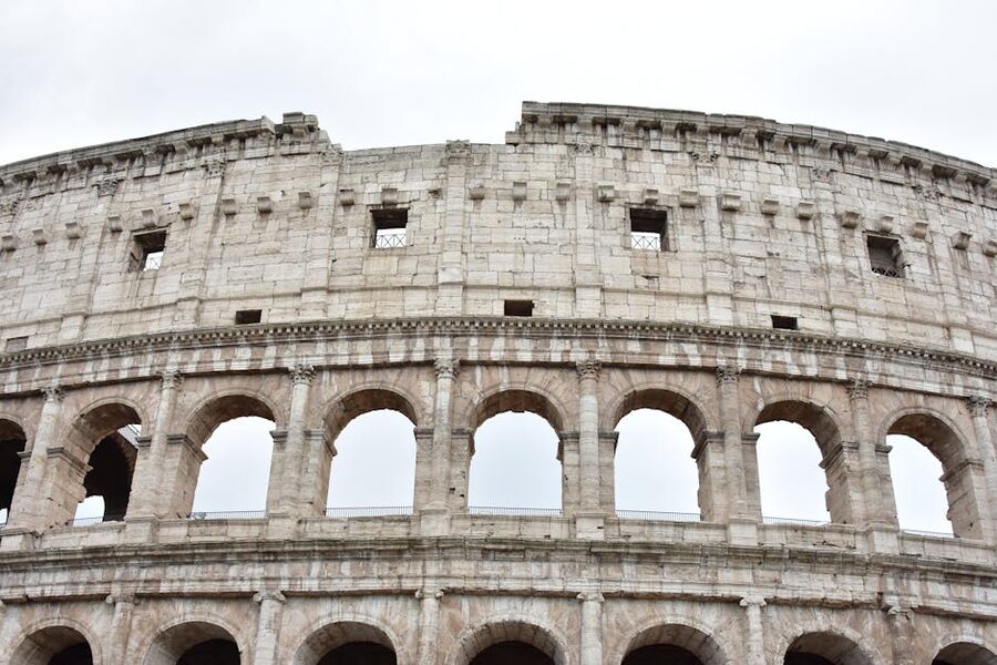 The Colosseum in Rome showing its iconic arched facade against a clear sky