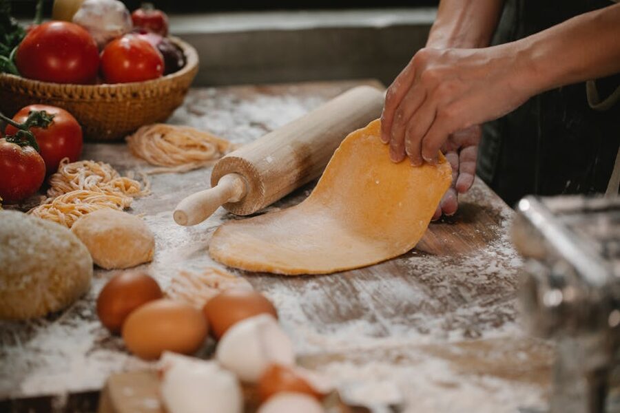 Kneading fresh pasta dough with a rolling pin