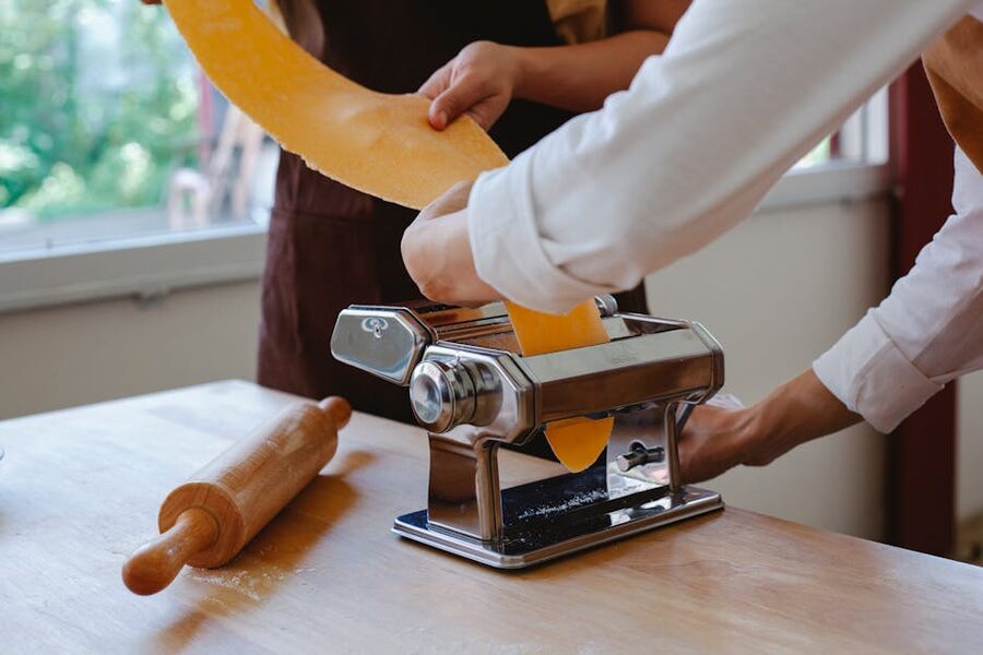 Traditional pasta maker rolling fresh pasta sheets