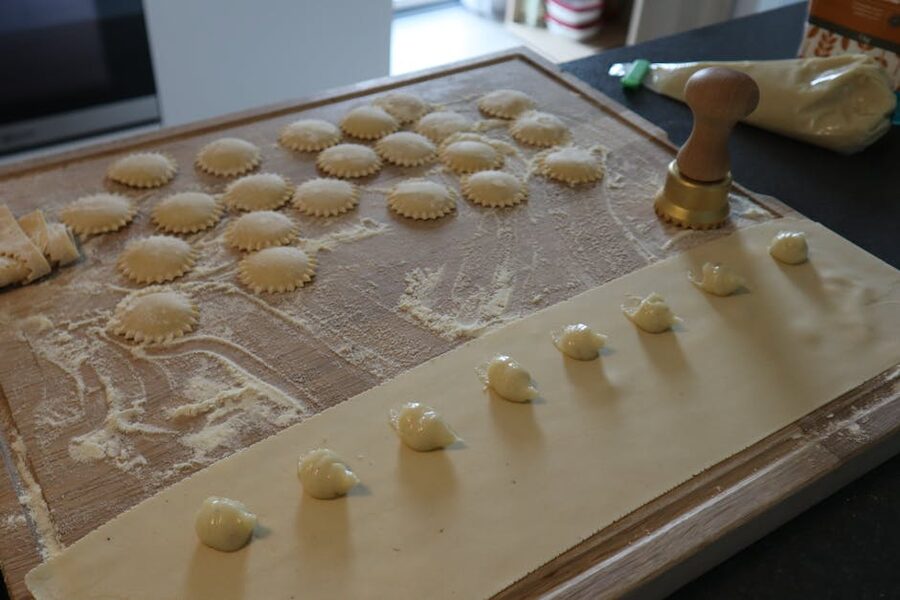 Fresh ravioli being stamped on a floured board