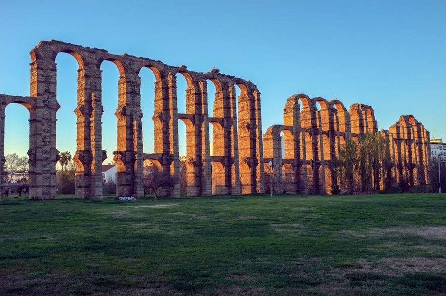 Ancient Roman aqueduct ruins illuminated by sunset