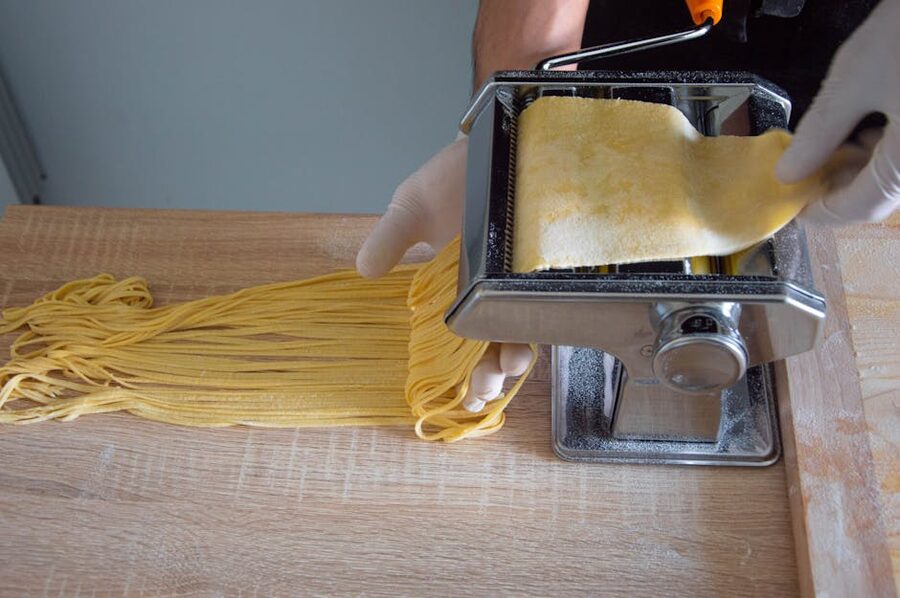 Hands feeding fresh pasta through a pasta machine in Rome
