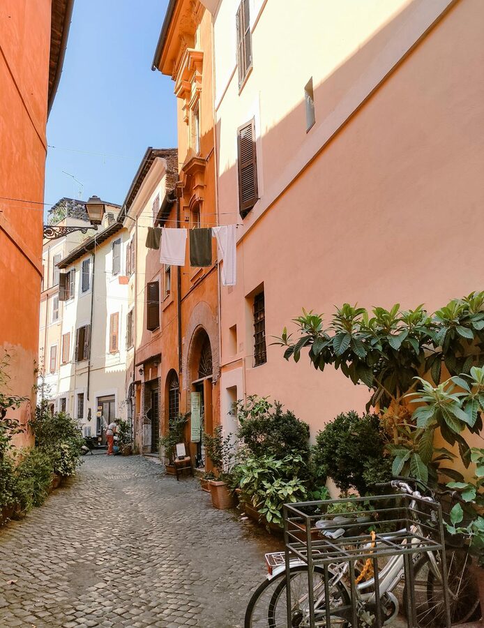 Sunlit cobblestone alley in Trastevere neighborhood of Rome
