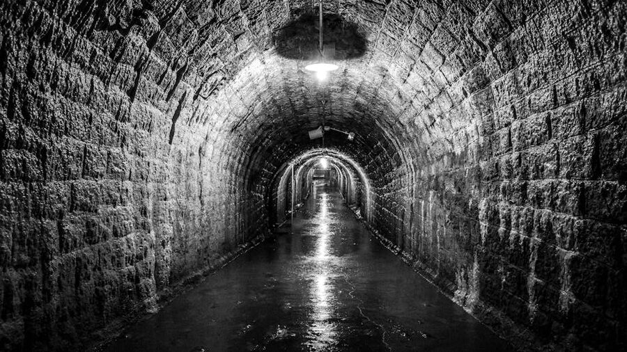 Dimly lit stone-walled underground tunnel