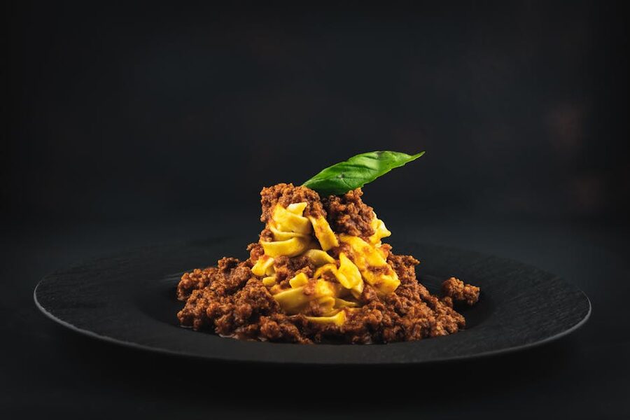 Spaghetti bolognese presented on a black plate