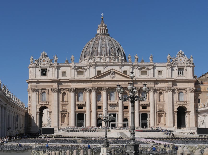 Grand facade of St Peters Basilica with visitors in the square