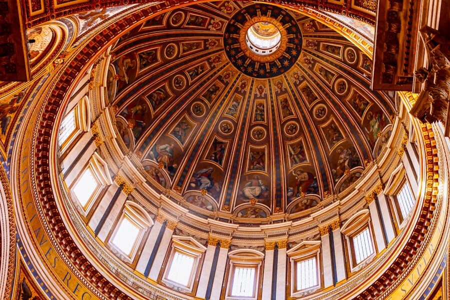 Looking straight up at the ornate dome inside St Peters Basilica