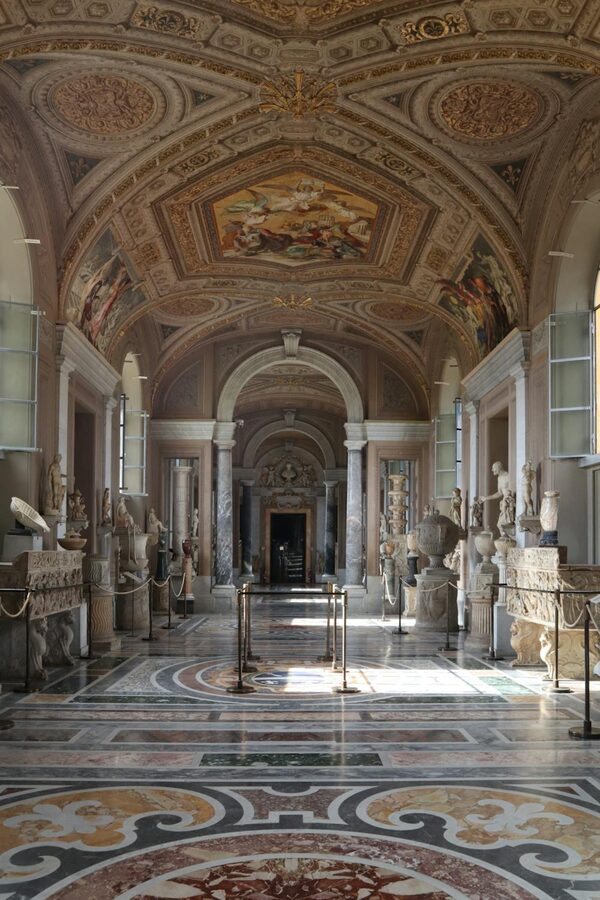 Ornate arched hallway inside the Vatican Museums with painted ceiling