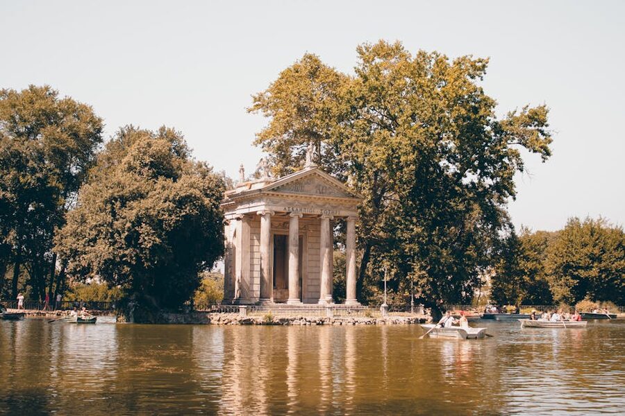 Temple of Aesculapius surrounded by lush greenery at Villa Borghese