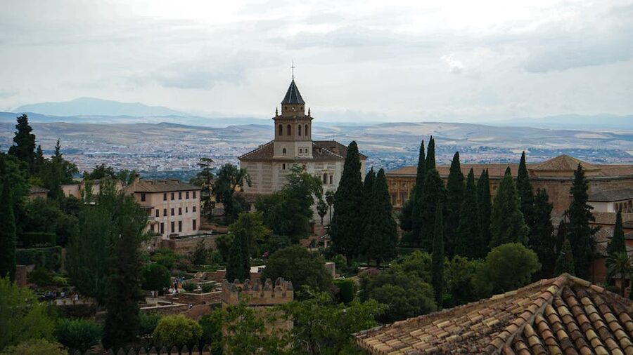 The Alhambra seen from a distance surrounded by green hills near Granada