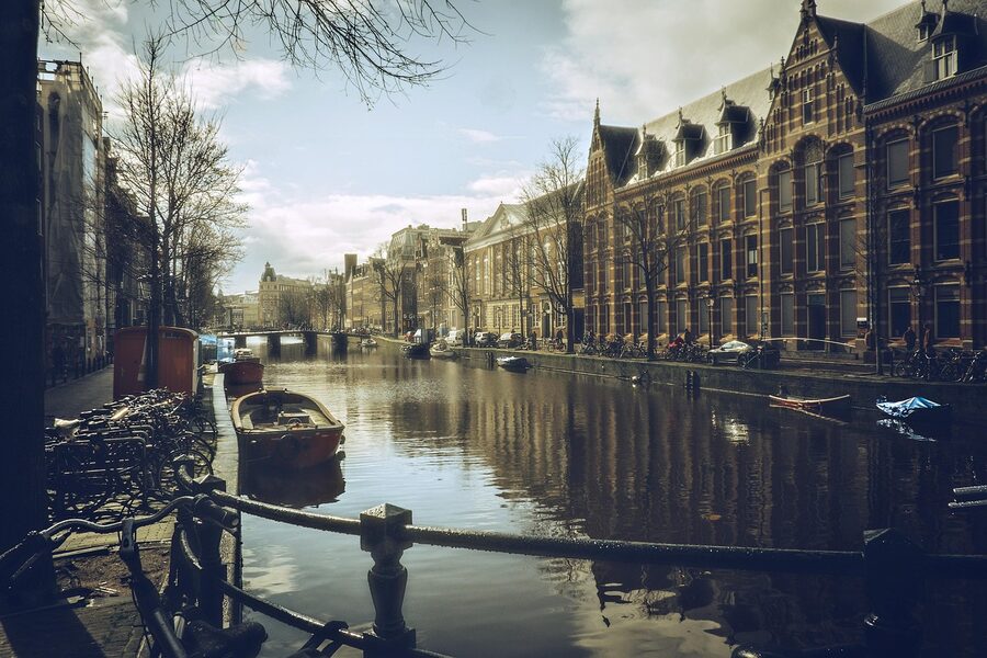 Small canal cruise boat moving through Amsterdam's central canal ring
