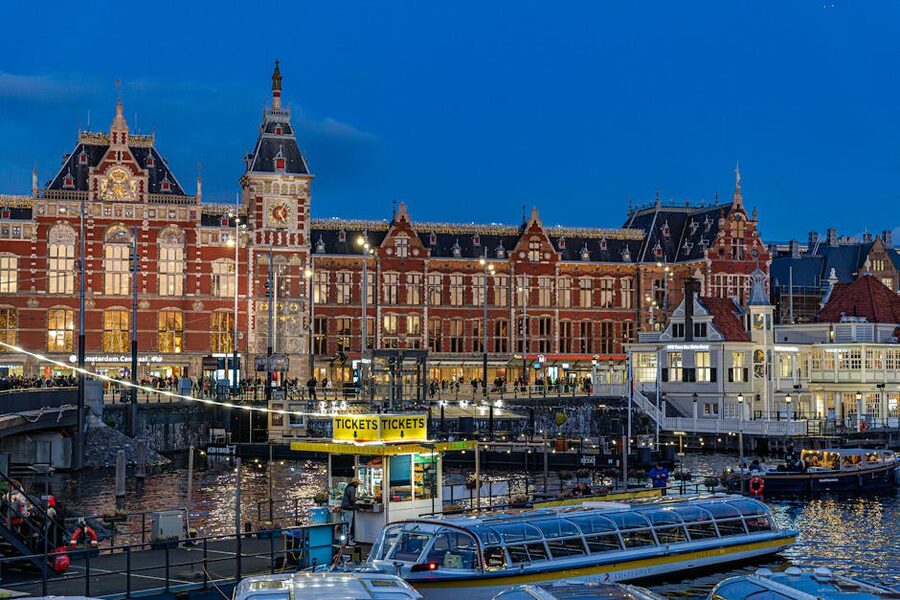 Amsterdam Centraal Station at dusk reflected in the canal in front