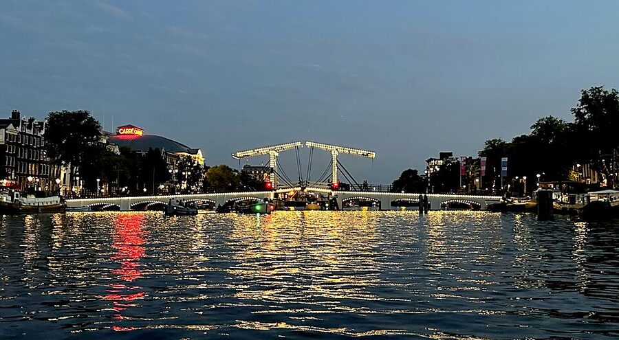 The Magere Brug strung with white lights at night reflecting on the Amstel river