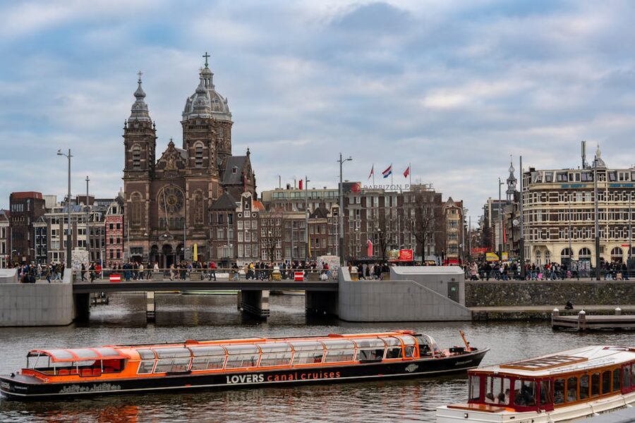 The Basilica of Saint Nicholas in Amsterdam viewed from the canal with a tour boat passing in front