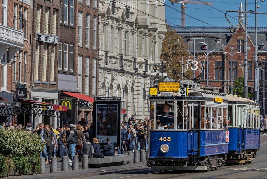 Blue tram on a busy Amsterdam street
