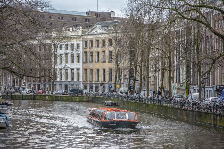 Amsterdam canal with tour boat in winter