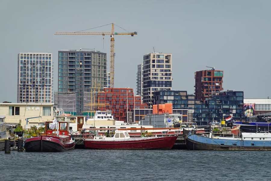 Contemporary buildings overlooking a busy harbour with moored boats Amsterdam