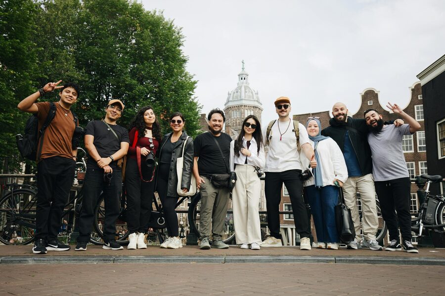 Group of people on an Amsterdam walking tour with historic building backdrop
