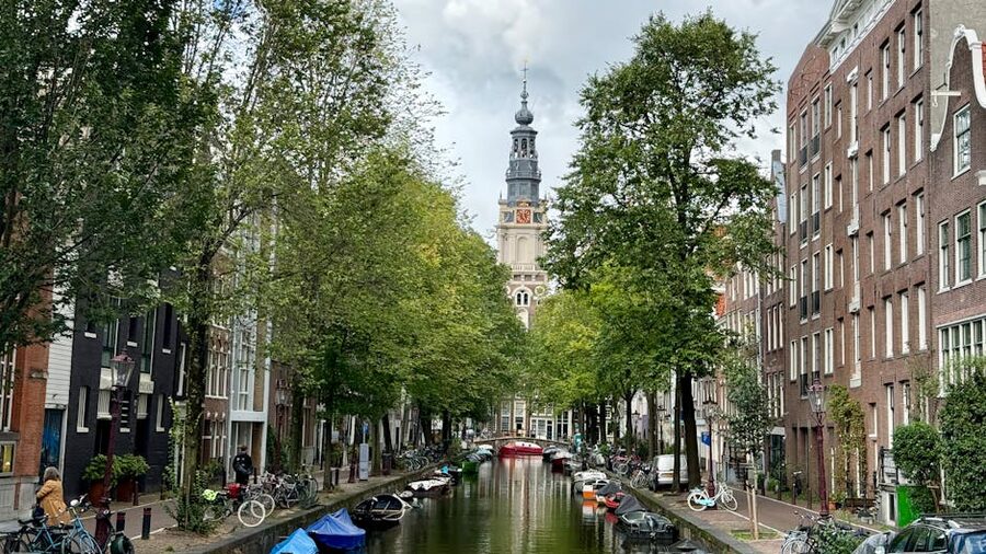 Westerkerk tower with bicycles by Amsterdam canal