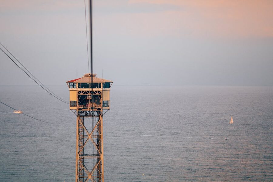 Sant Sebastià Tower of the Port Cable Car at sunset over Barcelona harbour