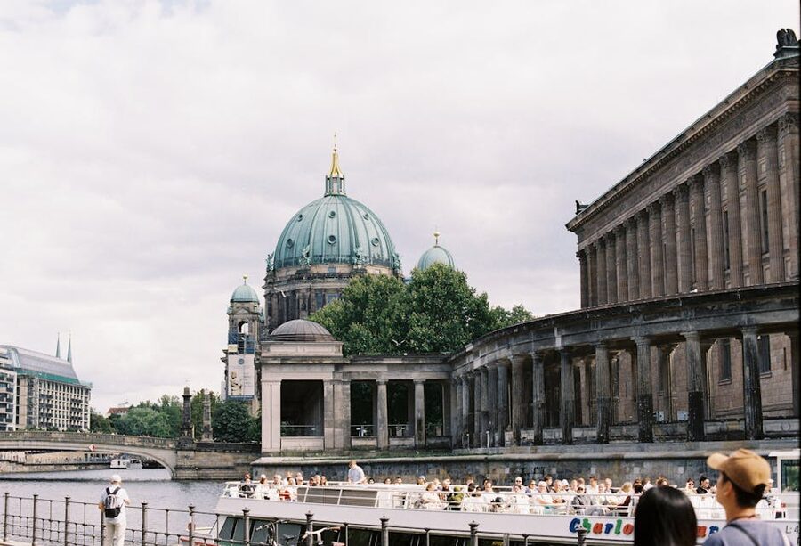 Berlin Cathedral with a river cruise boat passing on the Spree