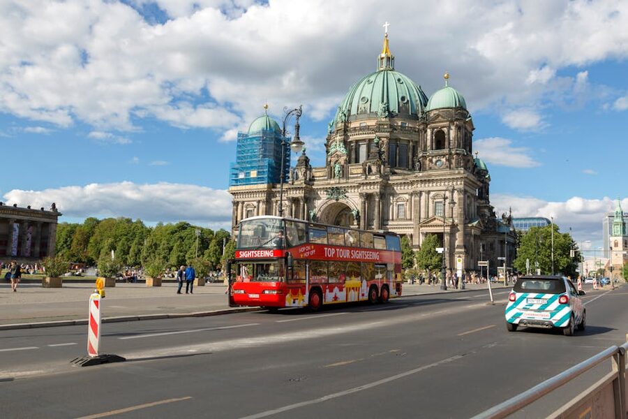 Double-decker sightseeing bus passes Berlin Cathedral on a sunny day