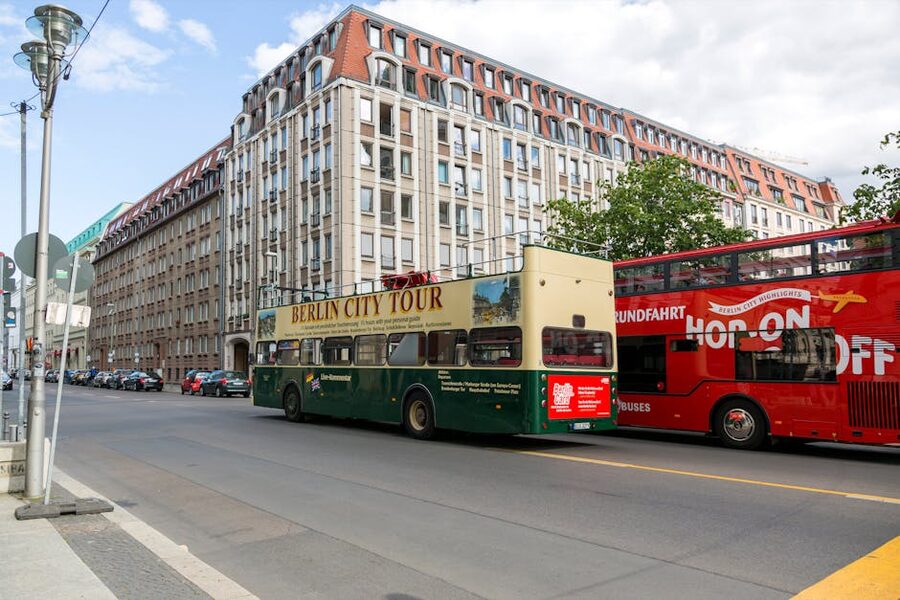 Double-decker tour buses driving through a Berlin street