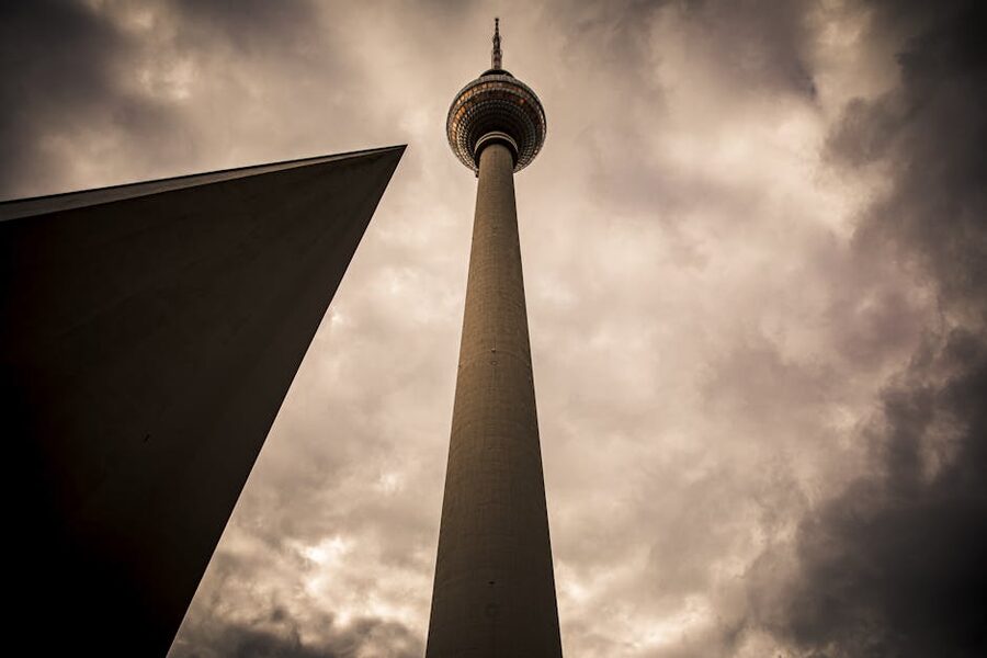 Low angle view of Fernsehturm against cloudy sky