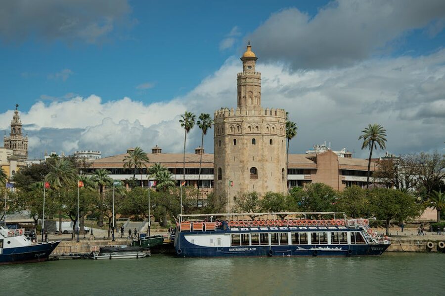 A cruise boat docked beside the Torre del Oro on the Guadalquivir