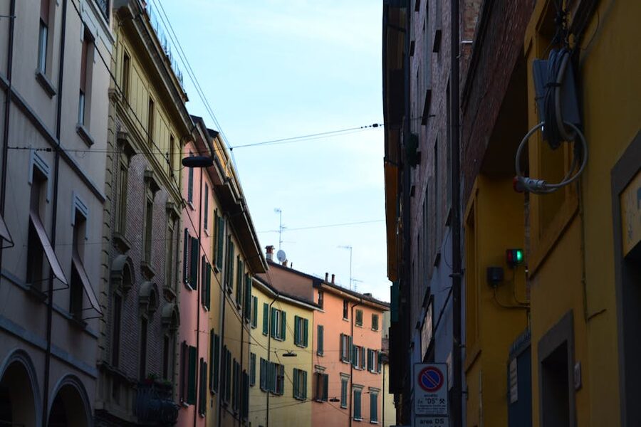 A narrow porticoed street in central Bologna with colourful buildings