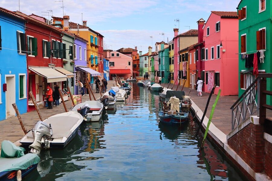 Burano canal with iconic colored village and reflections
