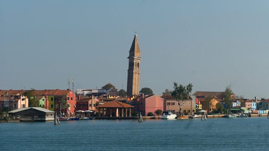 Burano colorful row houses lining a canal under clear blue sky