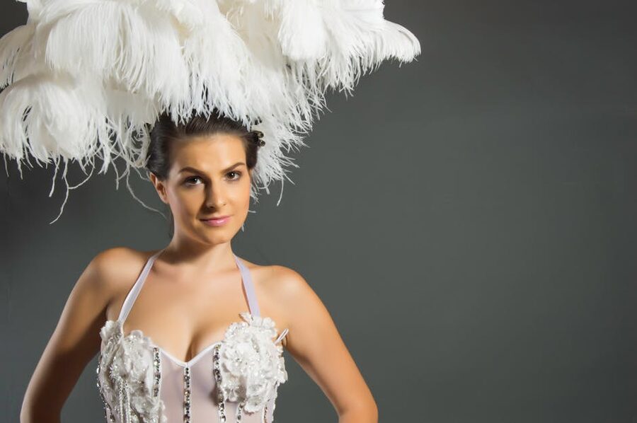 A performer in a feathered headpiece showing classic cabaret glamour