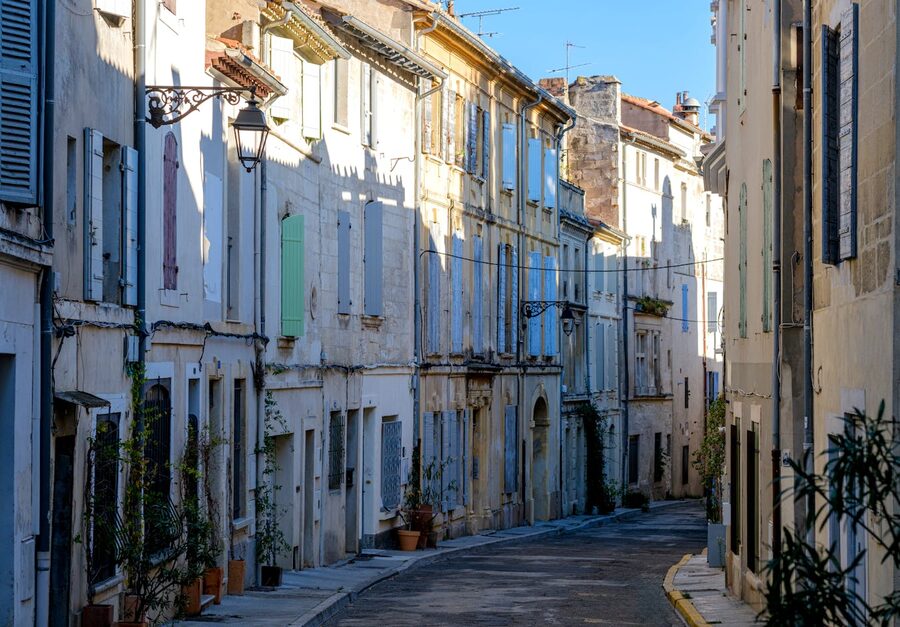 Sunlit narrow street in old Arles France