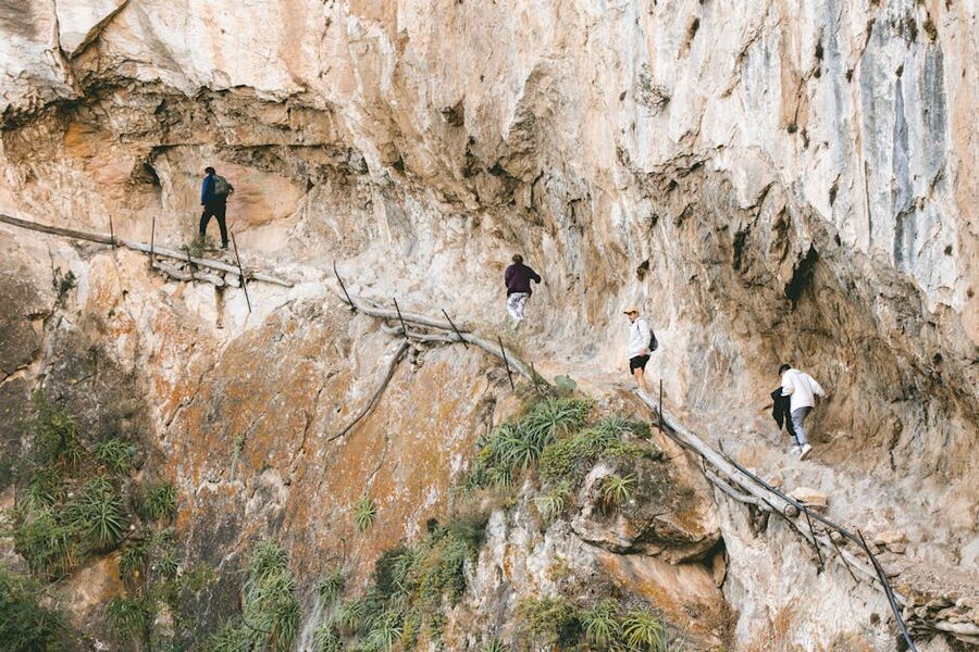 Hikers on a narrow rocky path of the Caminito del Rey