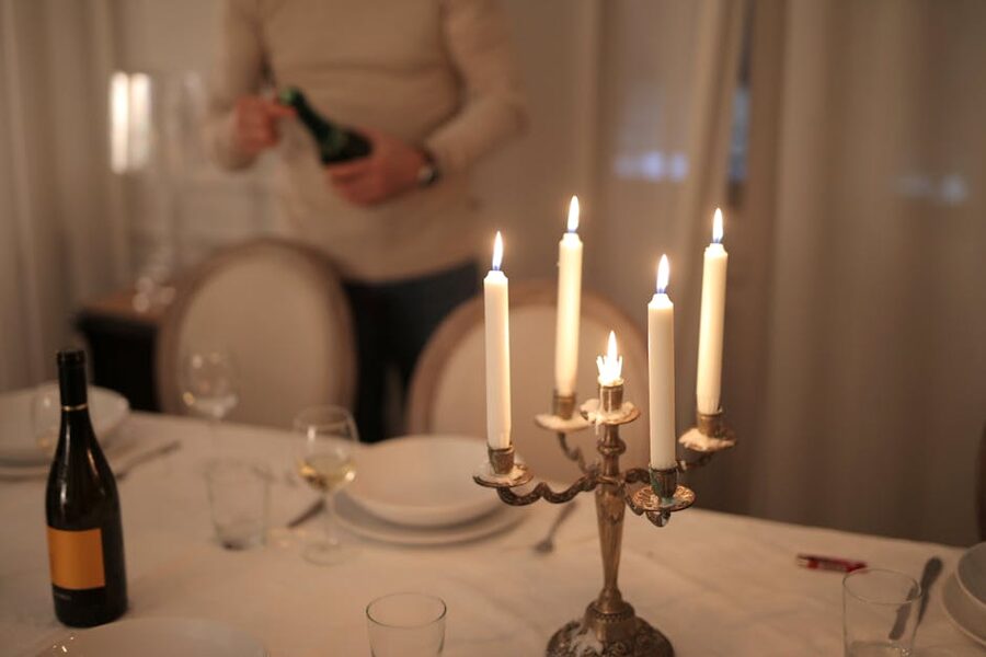 A candlelit dinner table set with wine glasses ready for service