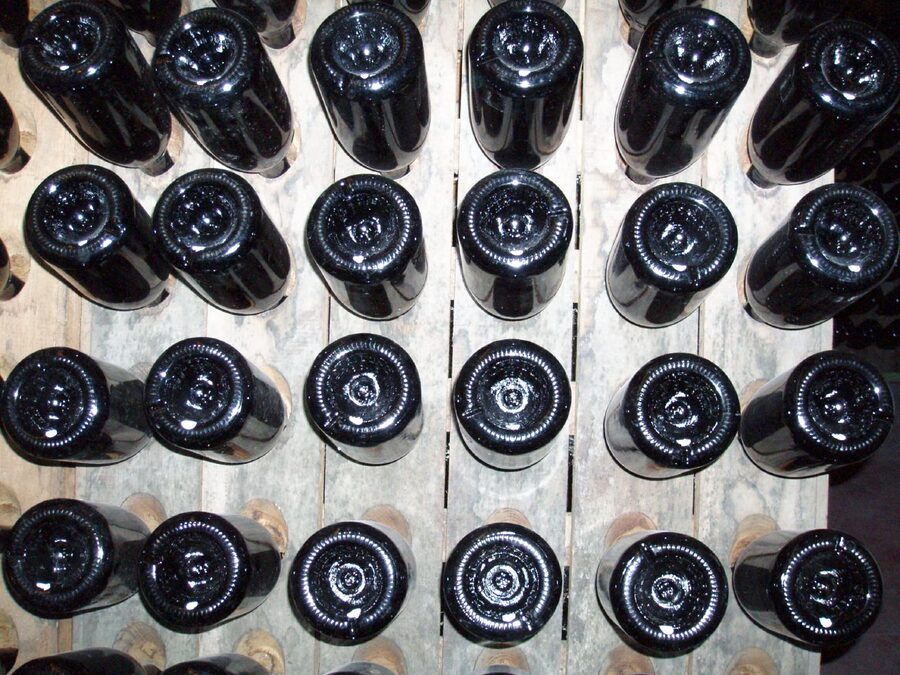 Champagne bottles upside down in a wooden pupitre riddling rack