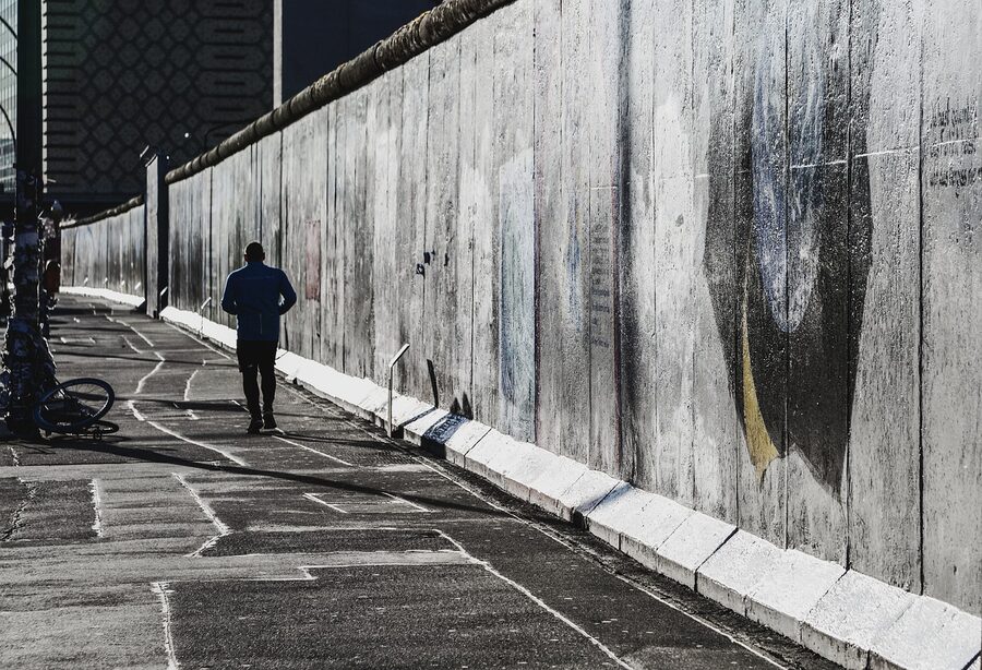 Jogger running past the East Side Gallery Berlin Wall murals