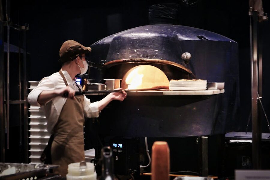 Chef working a wood-fired pizza oven in Naples