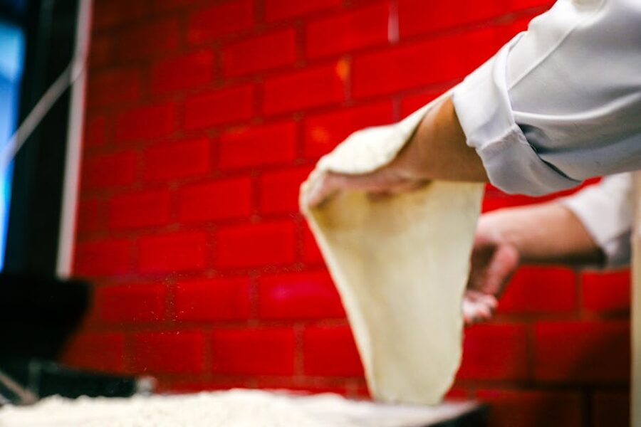 Pizzaiolo stretching dough by hand for a Naples-style pizza