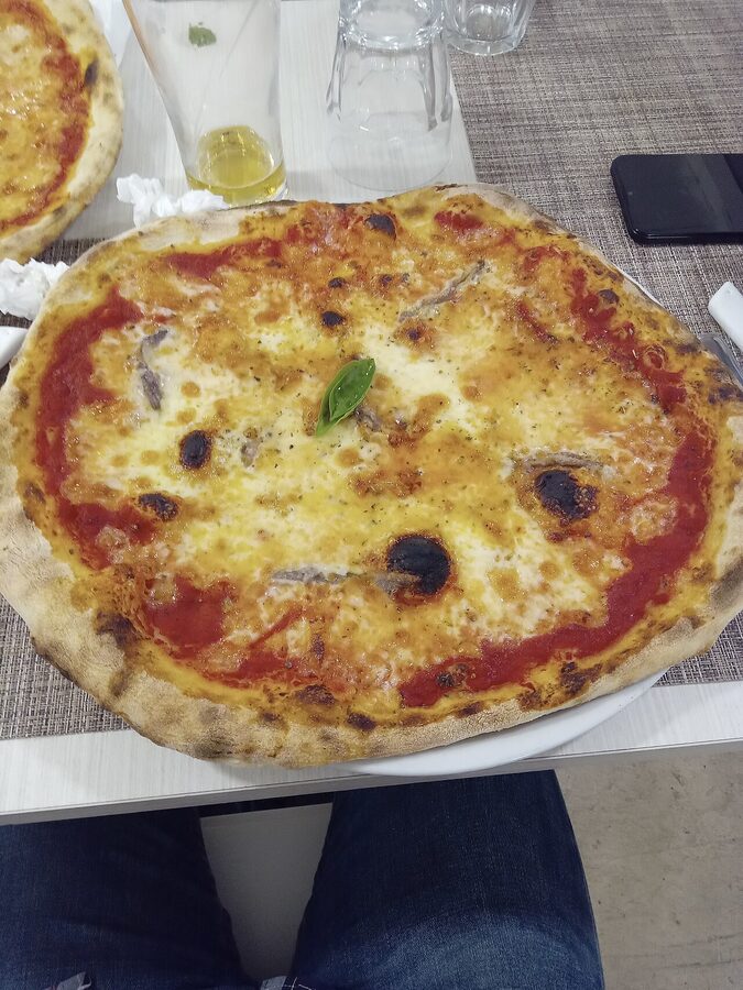 Naples-style pizza with charred crust served in 2024