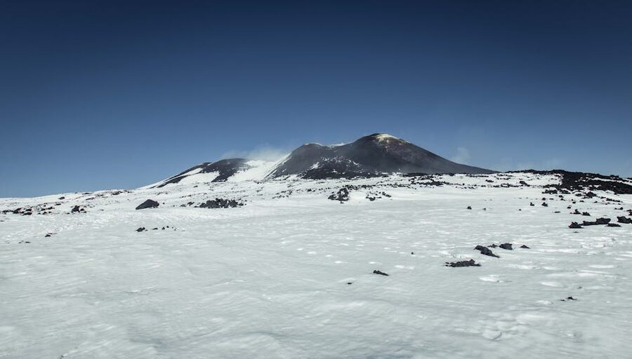 Mount Etna's snow-covered summit beneath a clear blue sky