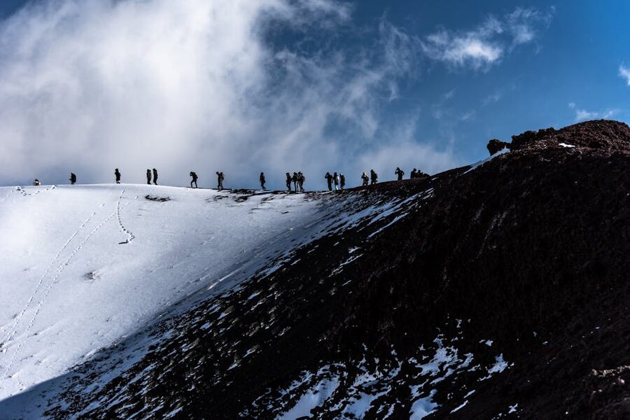 Trekkers on Mount Etna's snowy upper slopes