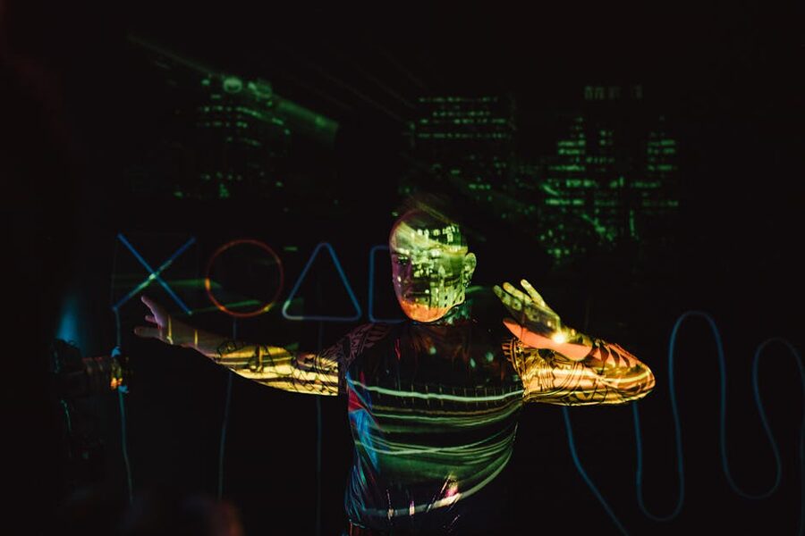 Figure standing inside a projection room with cityscape imagery on walls