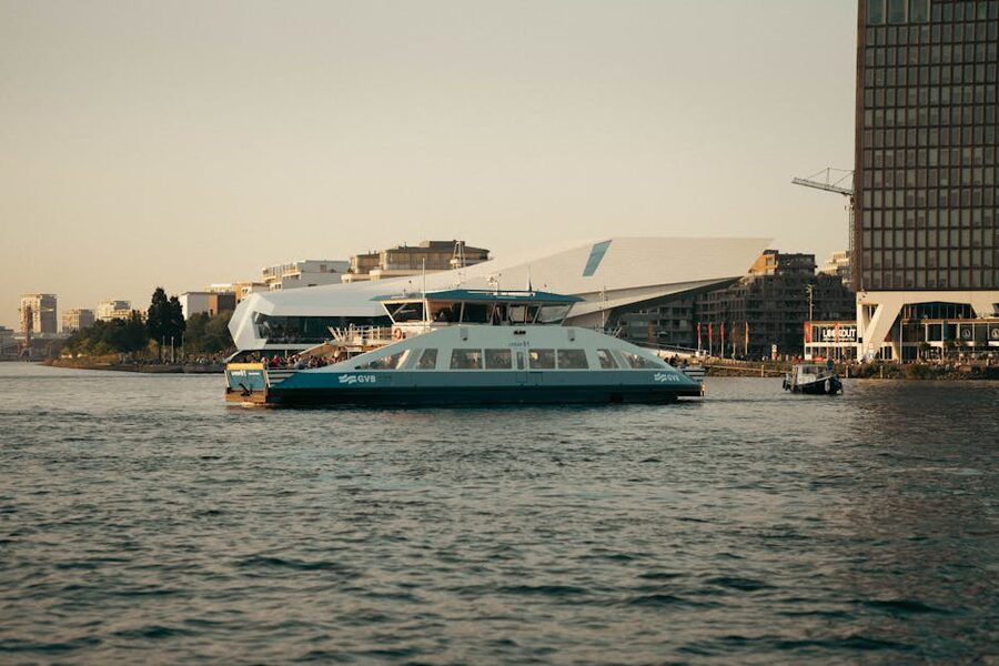 Modern ferry on Amsterdam waterfront at sunset