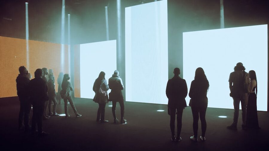 Visitors in front of large illuminated immersive art screens