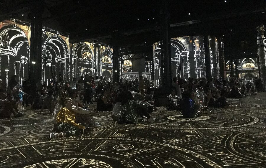 Visitors at floor level inside an immersive Klimt projection room
