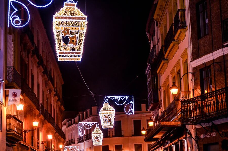 Hanging lanterns between old buildings on a Seville street