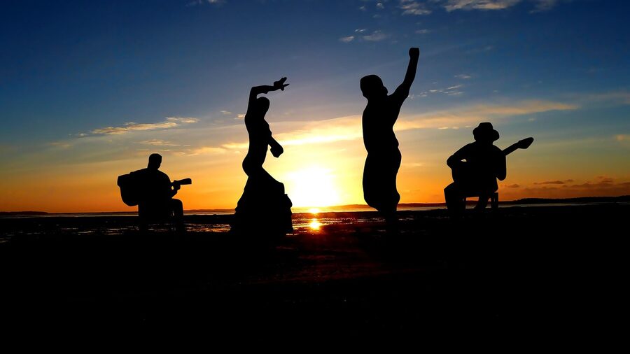 Flamenco guitarist silhouette at sunset