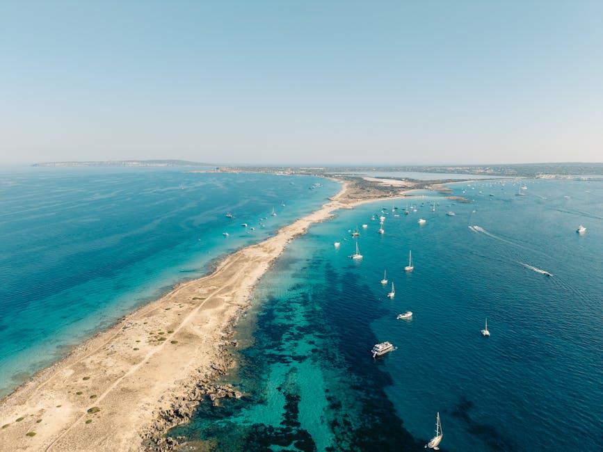 Aerial view of Formenteras coastline with turquoise waters and sailing boats